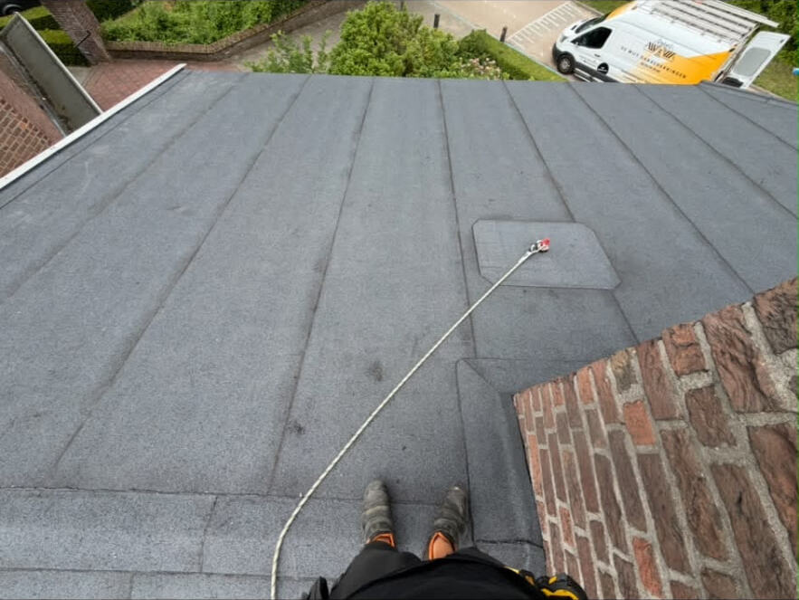 Strak afgewerkt plat dak van De Wijs Dakbedekkingen met de bedrijfsbus op de oprit